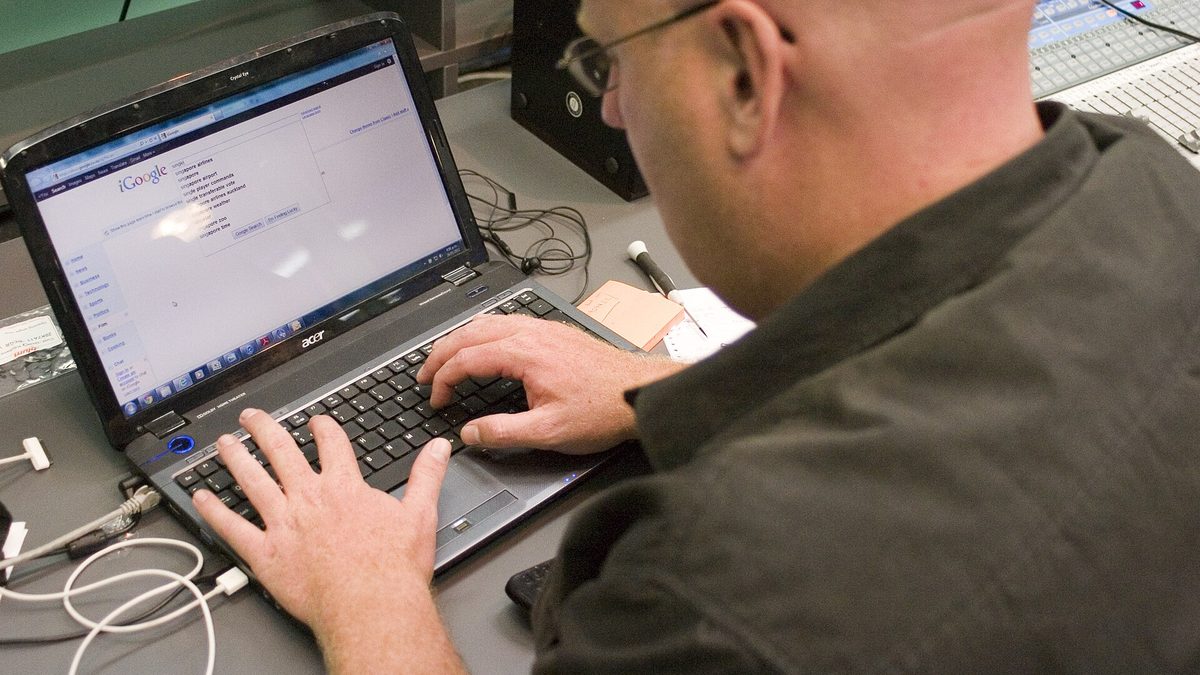 Person searching on Google with a laptop